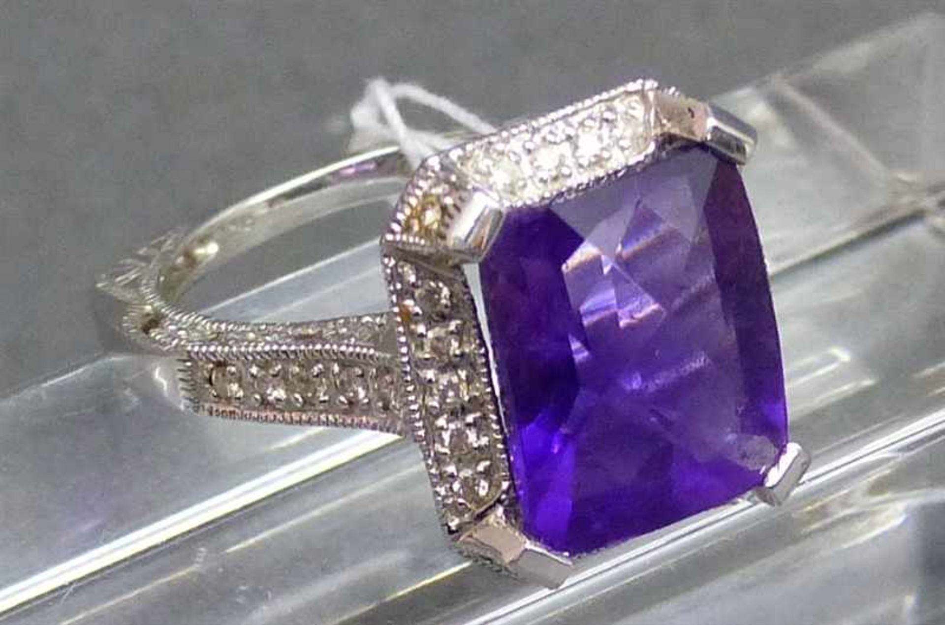 Damenring 14 kt. Weißgold, 1 Amethyst, Diamantbesatz, durchbrochen gearbeitete Fassung, teilweise