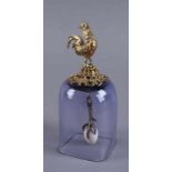 Glocke, Wien, violette Glaskuppel mit aufsitzendem Bronzehahn, im Inneren eine Gockelfuß mit Ei,