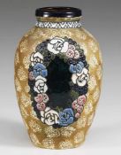"Amphora"-Vase Sandfarbener Scherben. Auf mattem grünlichem Fond helles stilisiertes Blumenmuster.