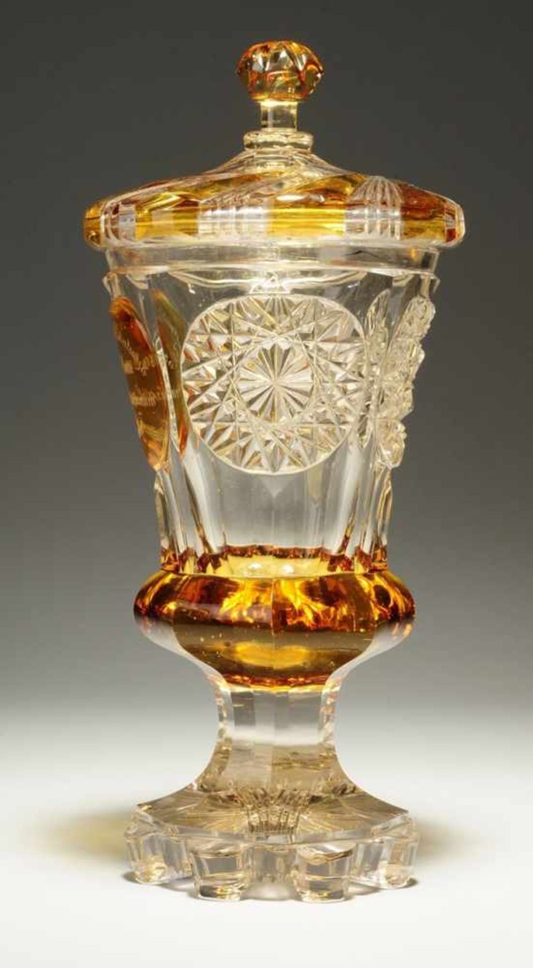 Biedermeier-Deckelpokal Farbloses Glas, part. gelb gebeizt. Formgeblasen. Facettierter Fuß u.