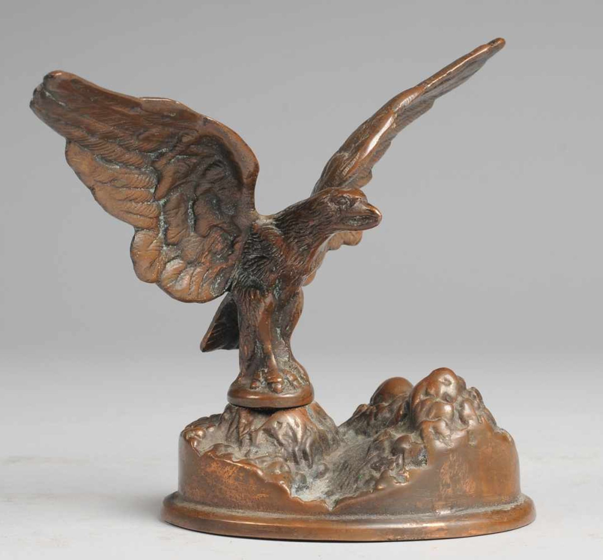 Adler Bronze, kupferfarben patiniert. Auf ovaler Naturplinthe mit Felsgestein Adler mit