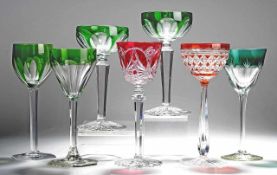 Sieben Römer Farbloses Kristallglas, part. grün bzw. rot überfangen. Formgeblasen. Scheibenfüße,