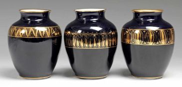 Drei Vasen Weiß, glasiert. Ovoide Form mit l. ausgezogener Mündung. Kobaltblauer Fond. Auf der