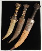 Drei Krummdolche Griffe mit Beschlägen aus Messing/Horn/Holz mit ornamentalem Dekor. Gekrümmte,