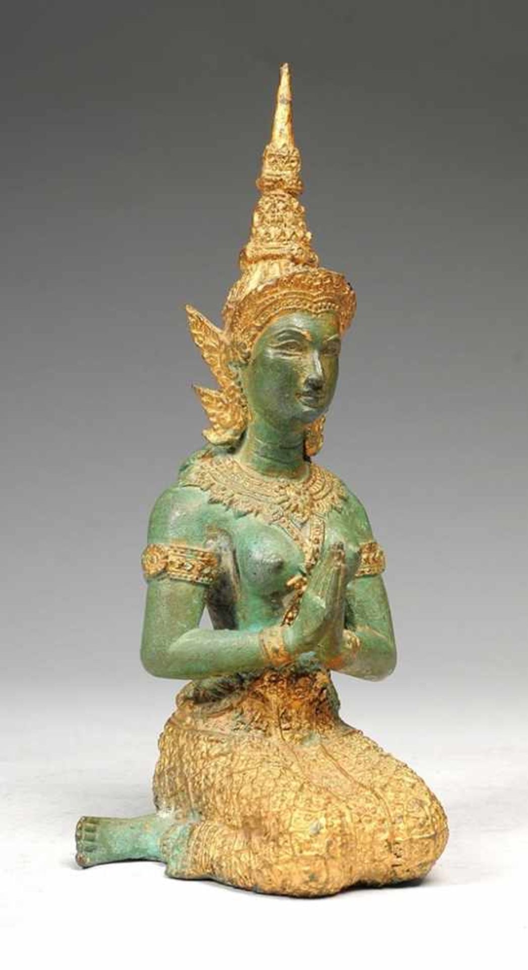 Statue einer Tempeldienerin Gelbguss, grün patiniert, part. vergoldet. In kniender Haltung, reich