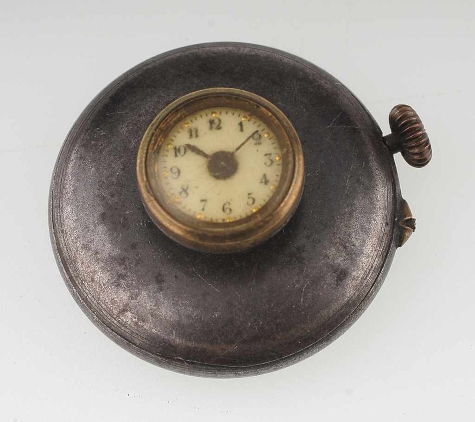Knopfloch-Uhr Brüniertes Stahlgehäuse mit aufgesetzter Uhr. Zifferblatt mit arabischen Ziffern.