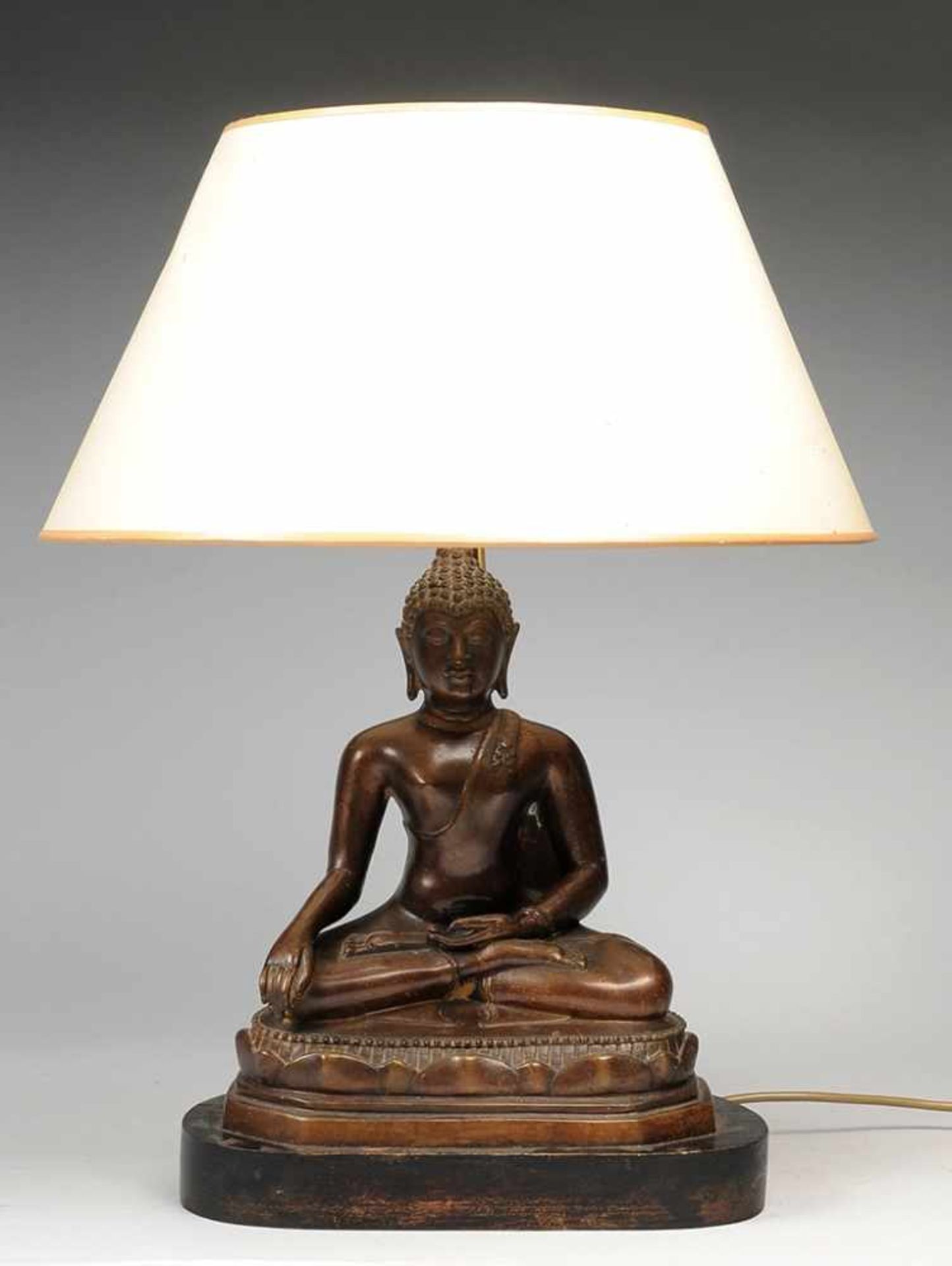 Tischlampe mit Buddhastatue 2-flg. Bronze, patiniert. Auf ovalem geschwärztem Holzsockel u.