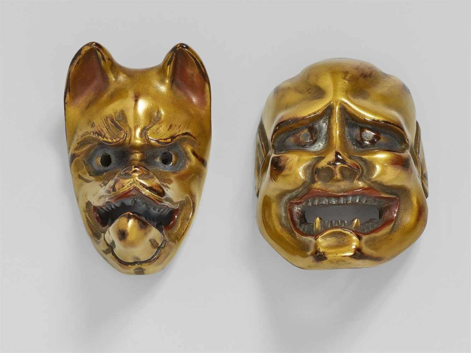 Two maki-e-lacquered wood mask netsuke. 19th century - a) A smiling man with large [...]