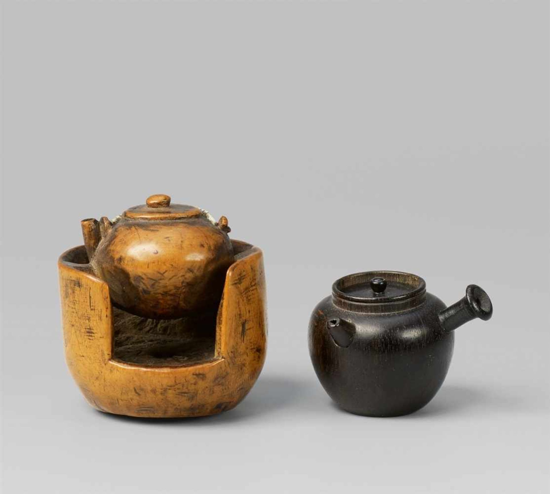 Two wood netsuke. 19th century - a) A teapot set into a hibachi, the handle and one [...]