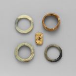 Fünf Jade- und Stein-Objekte Bestehend aus vier Armreifen, zwei mit archaisierenden Drachen in
