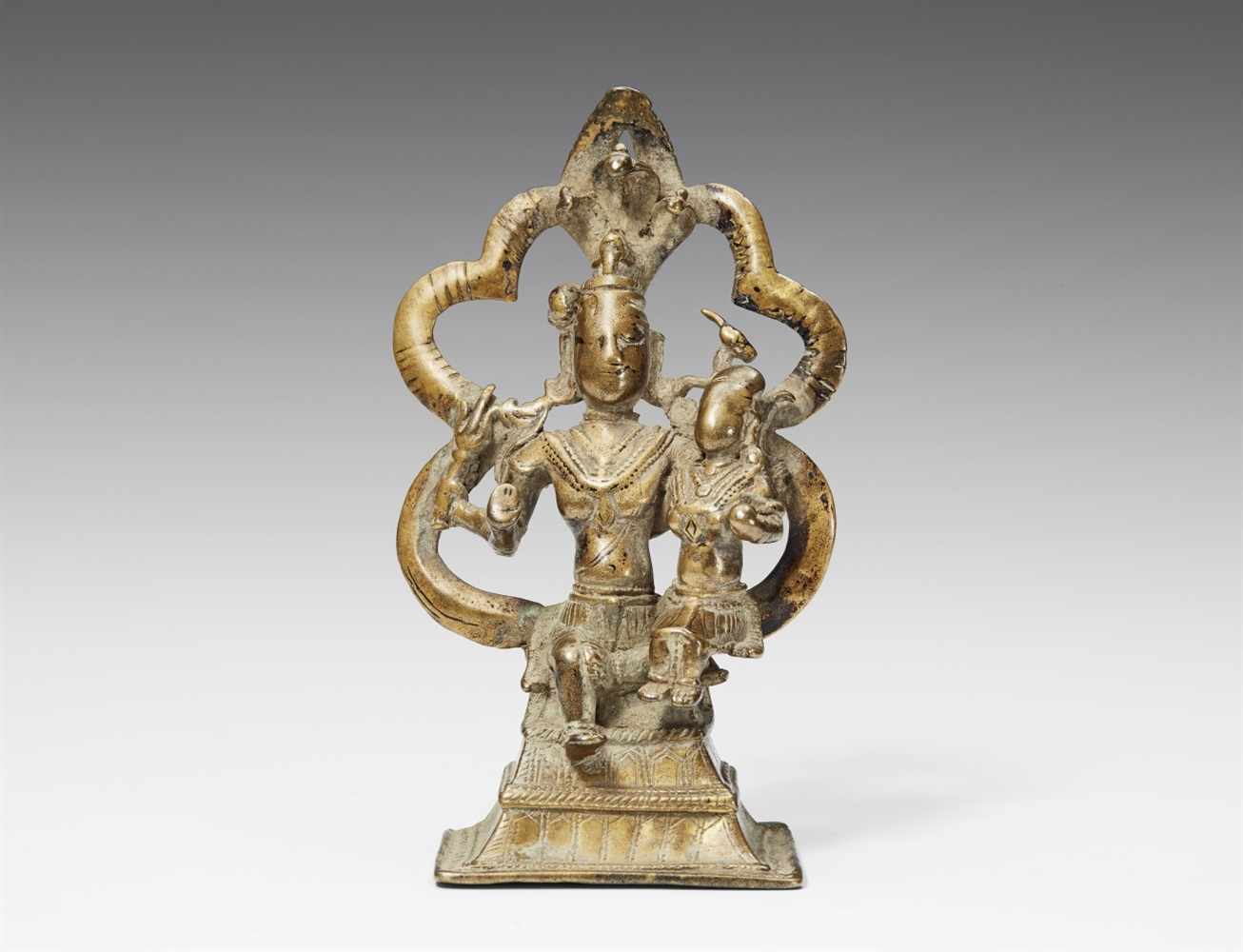 Shiva und Parvati. Messingfarbene Bronze. Nordostindien. 14./16. Jh. Der vierarmige Shiva, umgeben