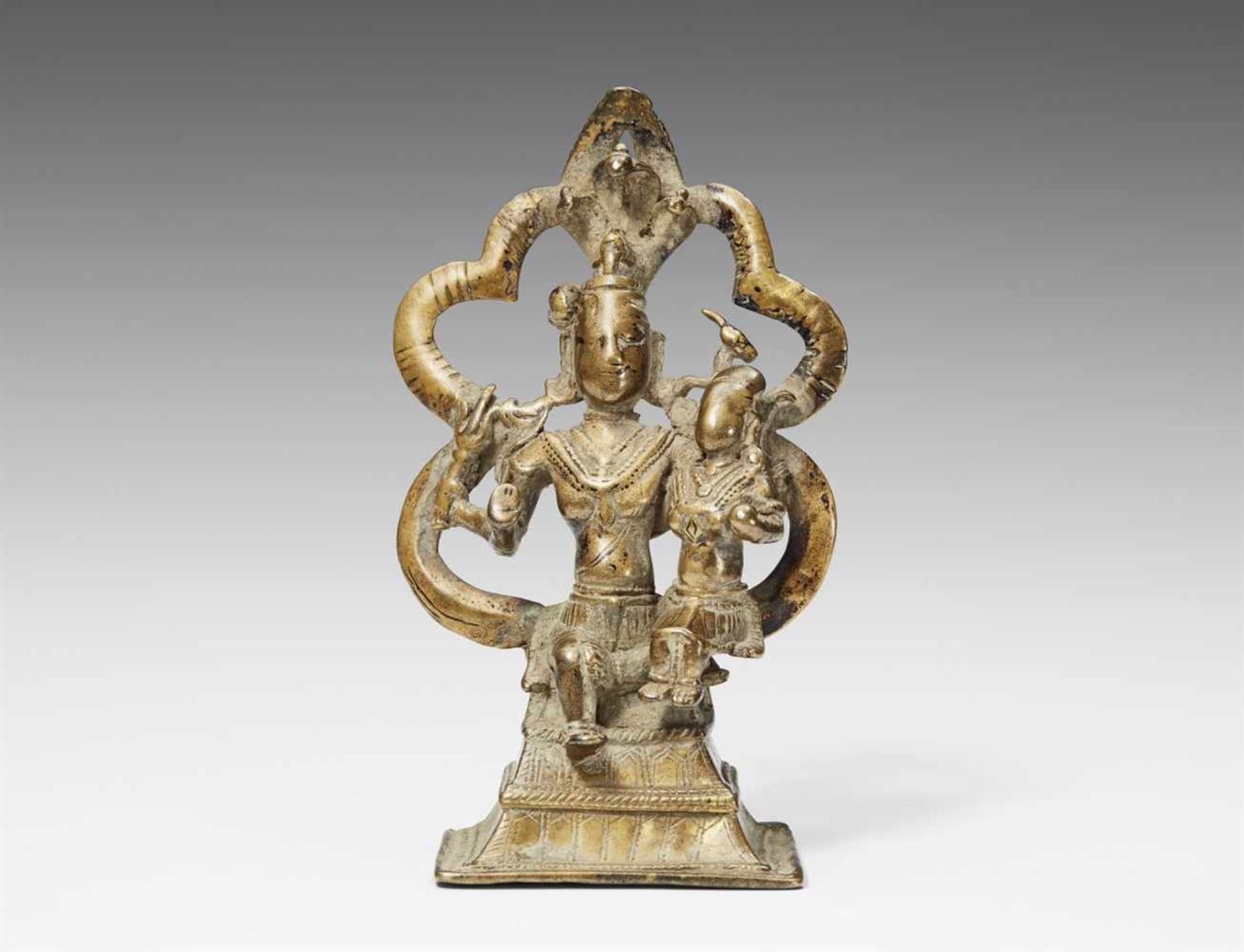 Shiva und Parvati. Messingfarbene Bronze. Nordostindien. 14./16. Jh. Der vierarmige Shiva, umgeben