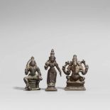Drei Figuren. Bronze. Südindien. 19. Jh. a) Gottheit mit Schwert und Schild, unter dem rechten Fuß