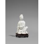 Blanc de Chine-Figur einer Guanyin. Qing-Zeit (1644-1911) Sitzende Guanyin, eine Rolle in der Linken