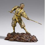 Samurai. Bronze. Im Miyao-Stil. Spätes 19. Jh. Im Ausfallschritt stehend, in beiden Händen einen