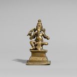 Figur des vierarmigen Ganesha. Gelbguss. 19. Jh. Sitzend auf hohem Sockel, an einer Süßigkeit