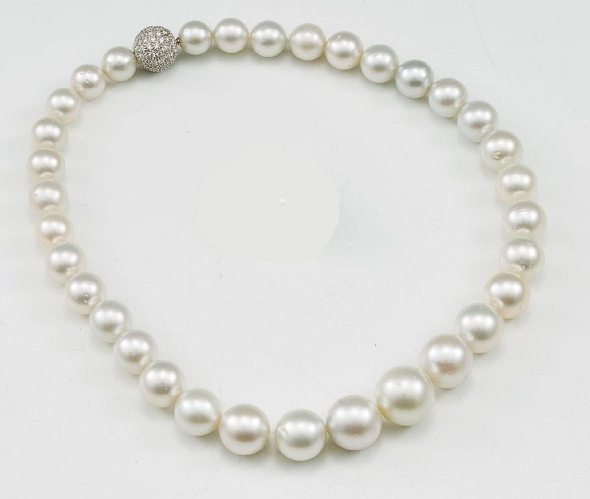 Leicht grau getönte Südseeperlenkette aus 33 Perlen nach Verlauf von D. 0,95-1,60 cm. 750/f.