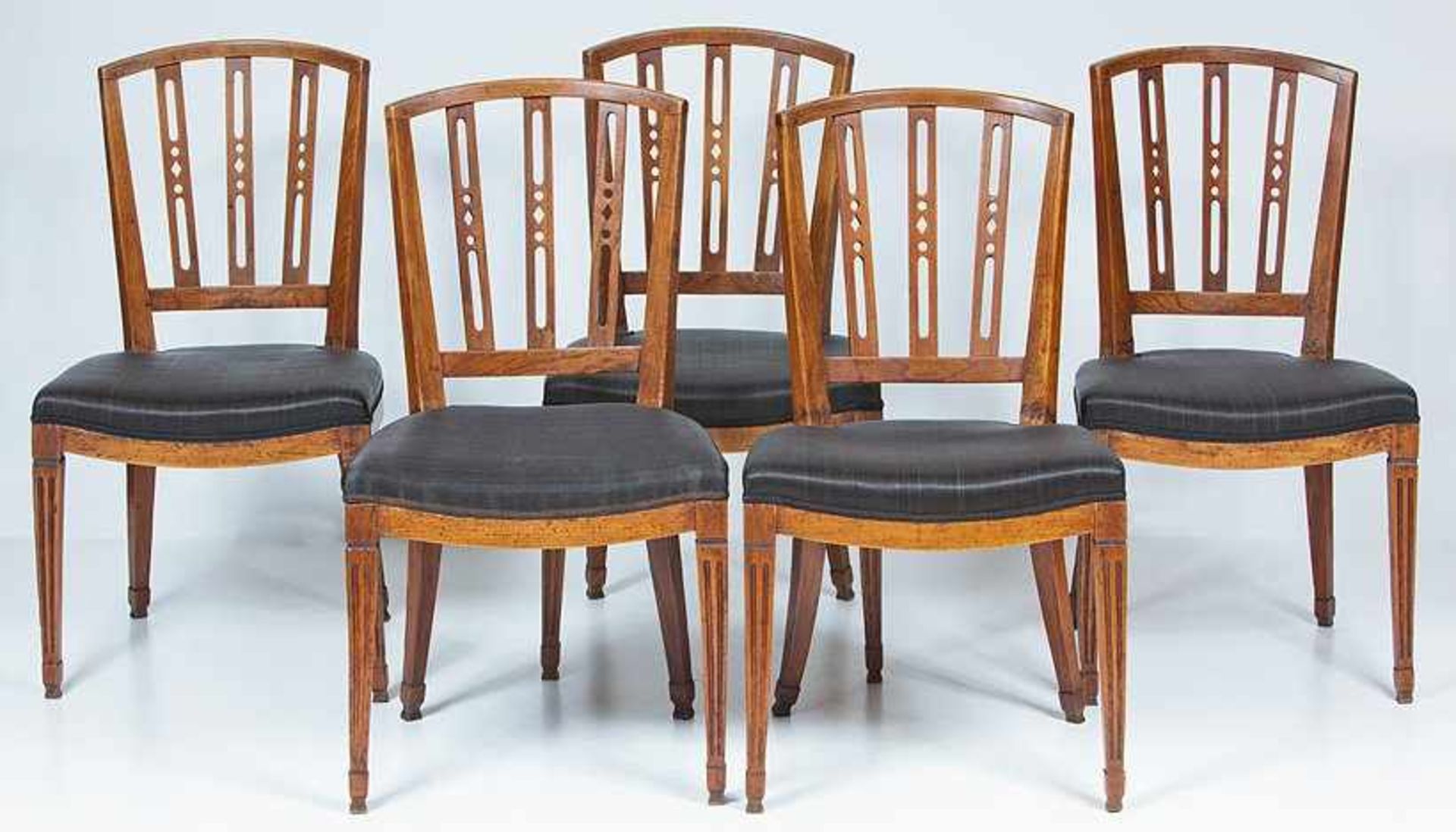 Fünf Stühle. Esche. Schlichte Gestelle mit abgesetzten, kannelierten Pfeilerbeinen und vorgerundeter