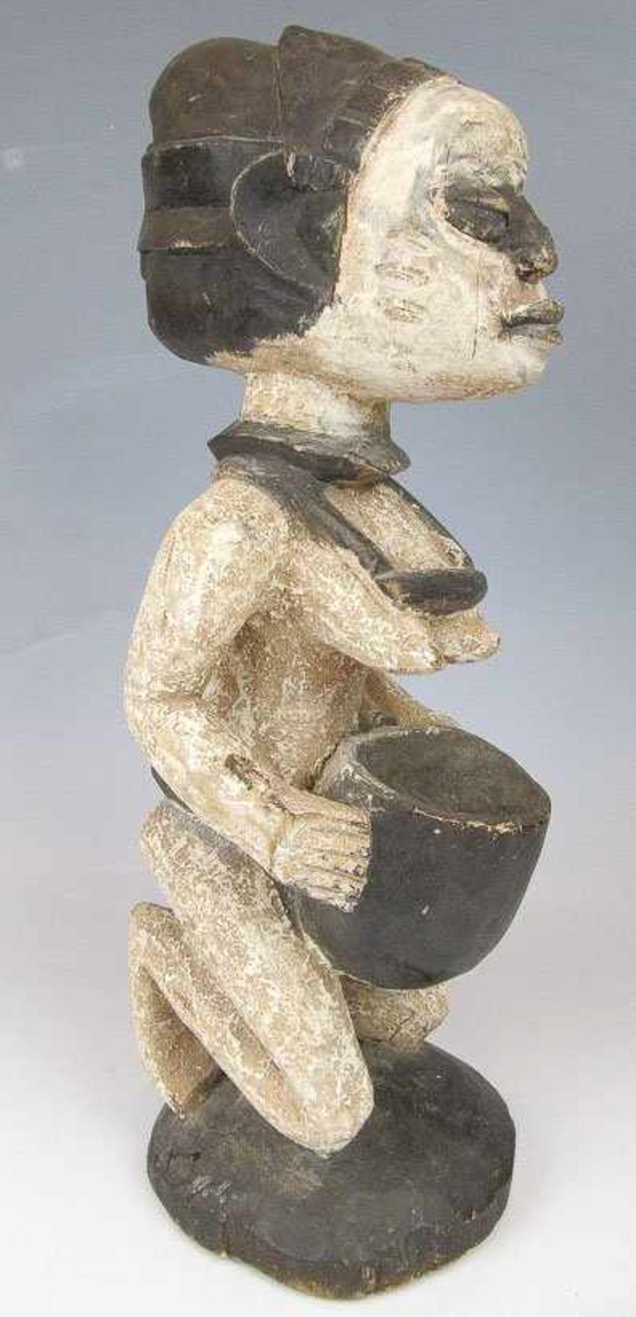 Kniende weibliche Figur. Holz, weiß und schwarz gefasst. Mit beiden Händen eine Schale haltend. H.
