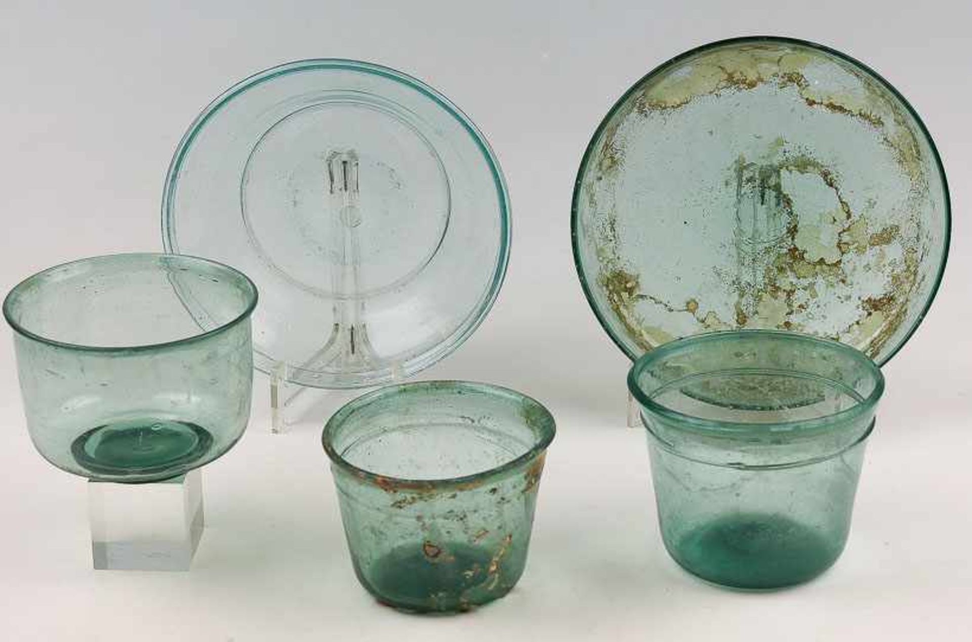 Fünf römische Glasgefäße. Blaugrünes Klarglas. Tlw. gering versintert. 3 Näpfe. Hohe, nach oben
