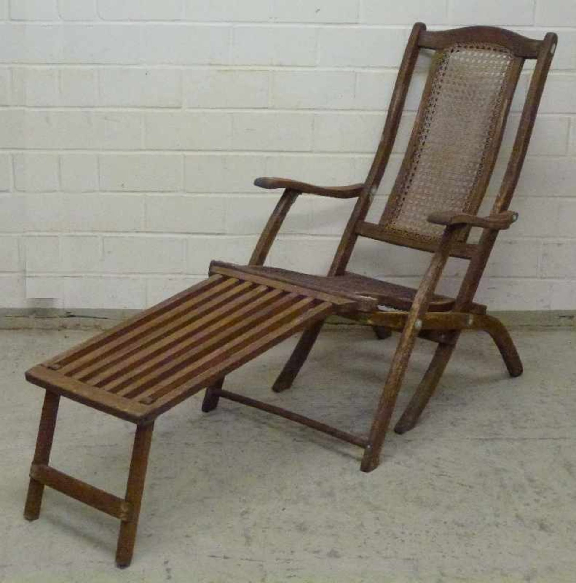 Liegestuhl sog. Deckchair, Anf. 20.Jh. Buche, Rohrgeflecht, klappb. Scherengestell, Armlehnen,