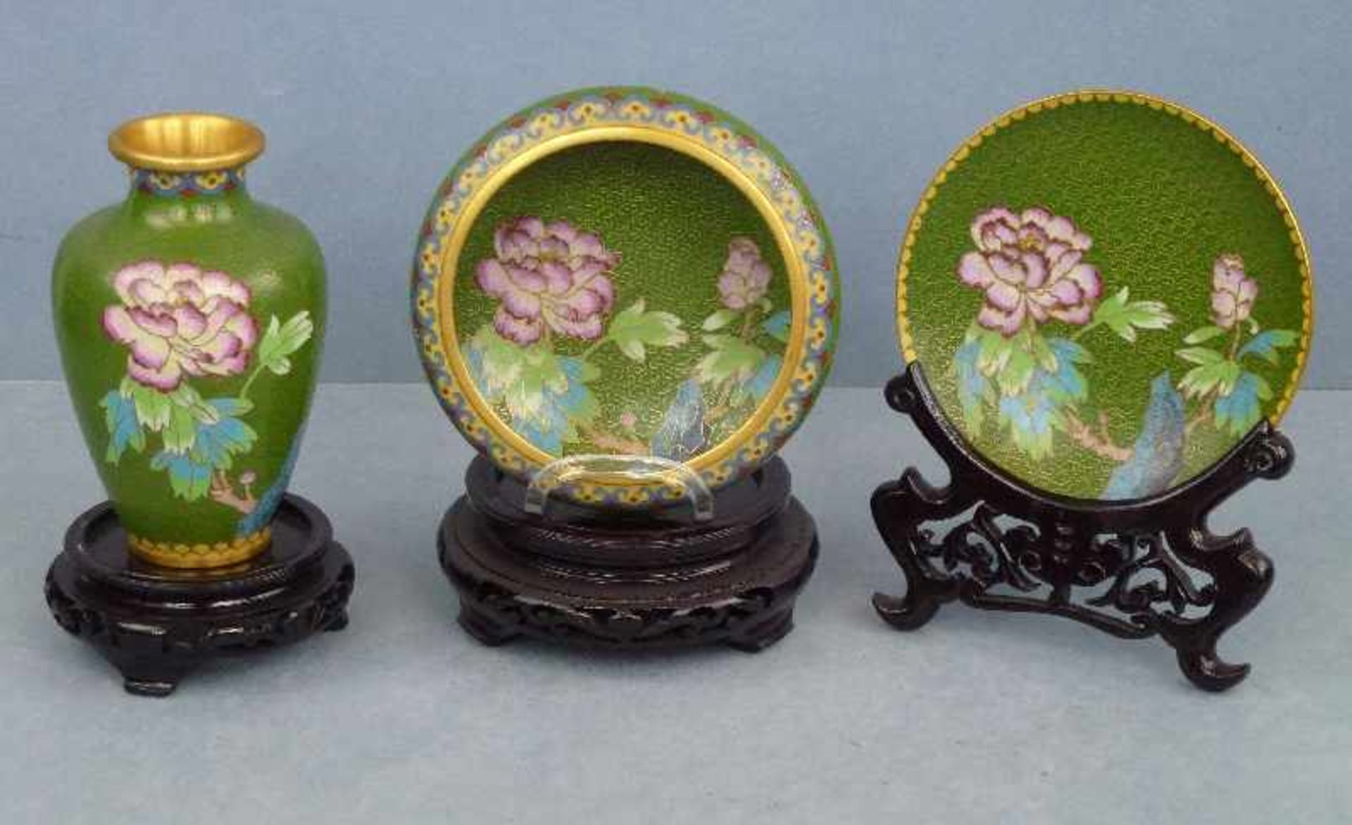 Vase, Schälchen und Teller, China Cloisonne, polychrome Blumen auf grünem Grund, Holzsockel, H