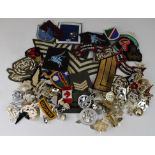 Tin full of various cloth badges and staybright cap badges (qty)