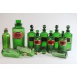 Apothecary. Thirteen green glass apothecary jars / bottles, mostly with stoppers and labels