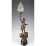 Spelter (?) lamp depicting a figure kneeling on a Lion, holding a torch, with glass flame cover (