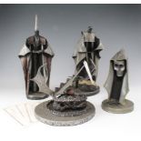 Four unusual metal sculptures, depicting a skull, wizard, King Arthur and one other, each with