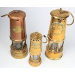 Miners Lamps.Three brass & copper miners lamps, comprising Protector Lamp & Lighting Company,
