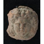 Roman terracotta, facing bust youthful boy surounded by curly flowing hair, c.48mm. across with a