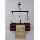 Set of scales mounted on a mahogany base with drawer, with a collection of weights, together with