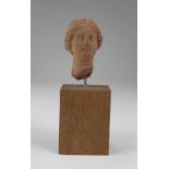 Roman solid? terracotta bust of a female of c.45mm. high, with elaberate hair style, parted down the
