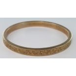 Large 9ct bangle with floral decoration, hallmarked Birmingham 1924?. Aprrox 78mm dia, 14.5g