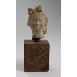 Small Roman pale terracotta bust of a female with very elaberate hair style, tied up with ribbons on