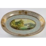 Oval dish with hand painted central scene depicting a boat in a bay, gilt decorated border, circa