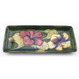 Moorcroft green rectangular dish with floral decoration, original paper label to base, length 20.5cm