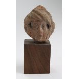 Roman terracotta male head with boyish Greecian features, the treatment of the eyes being outlined