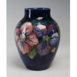 Moorcroft blue baluster vase with floral decoration, signed to base 'WM', height 17cm approx.