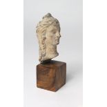 Head and neck of a noble woman, c. 75mm. high, in stone? long hair brushed back behind ear-rings,