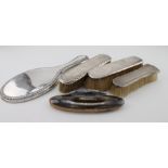Three silver backed brushes, silver top of a nail buffer and a silver backed mirror, various
