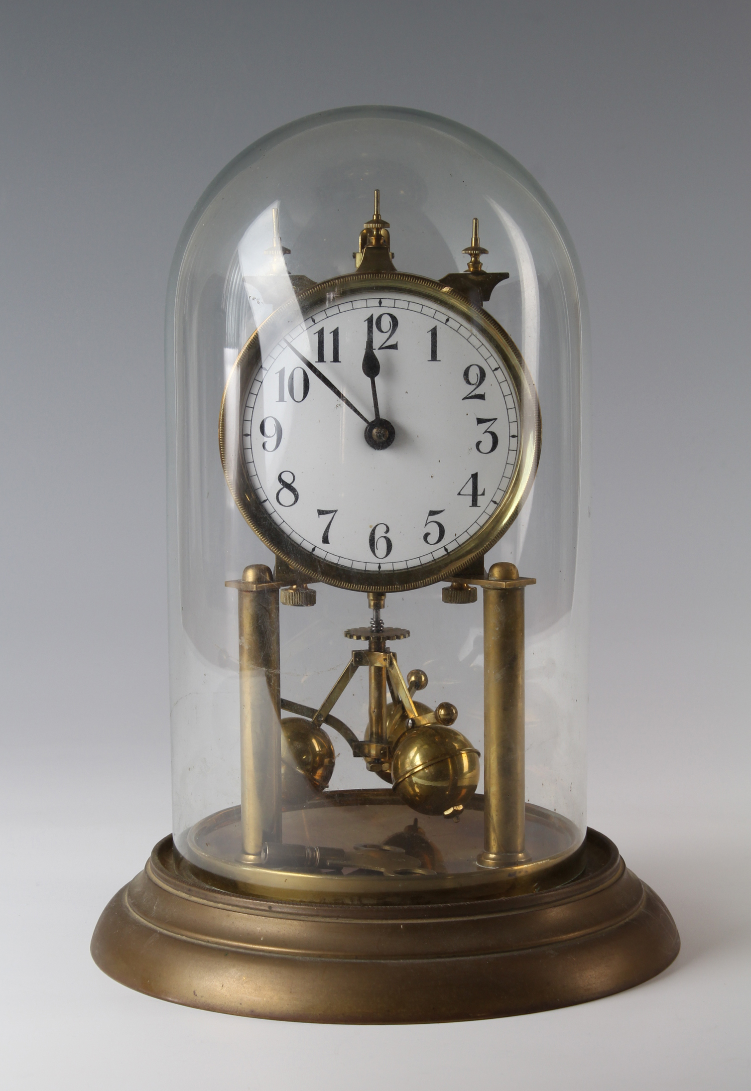 Brass anniversary clock, circa early 20th century, with glass dome, white enamel dial with Arabic