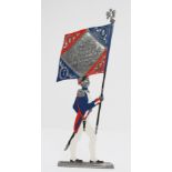 Diecast metal painted figure, depicting a French soldier holding a flag, flag reads 'Garde Imperiale