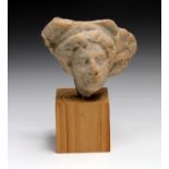 Roman terracotta bust of young female with hair waved around, wearing large head-dress the side of