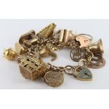 9ct / Yellow metal charm bracelet with a varied selection of charms attached. Total weight 59.7g