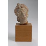 Small Roman pale terracotta bust of female, angled in a melancholy manner, c.42mm. high, with