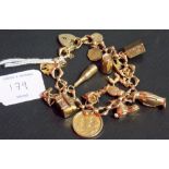 9ct gold charm bracelet with various charms including a half sovereign, weight overall 41.3g