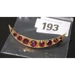 Edwardian rose gold rubies and diamond set crescent brooch, with nine graduated ruby between small