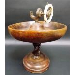 A nutcracker in the form of a ship's wheel with an oak bowl and on oak barley twist pedestal.